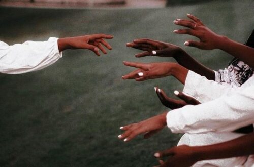 Female hands with short, neatly shaped nails painted in a smooth white color.