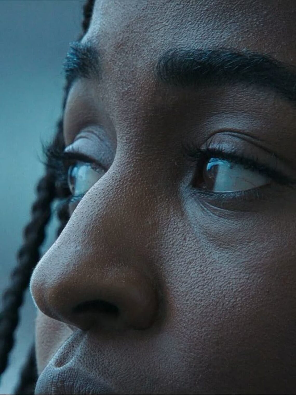 An image of a sad, black girl's face up-close, showing only her facial features