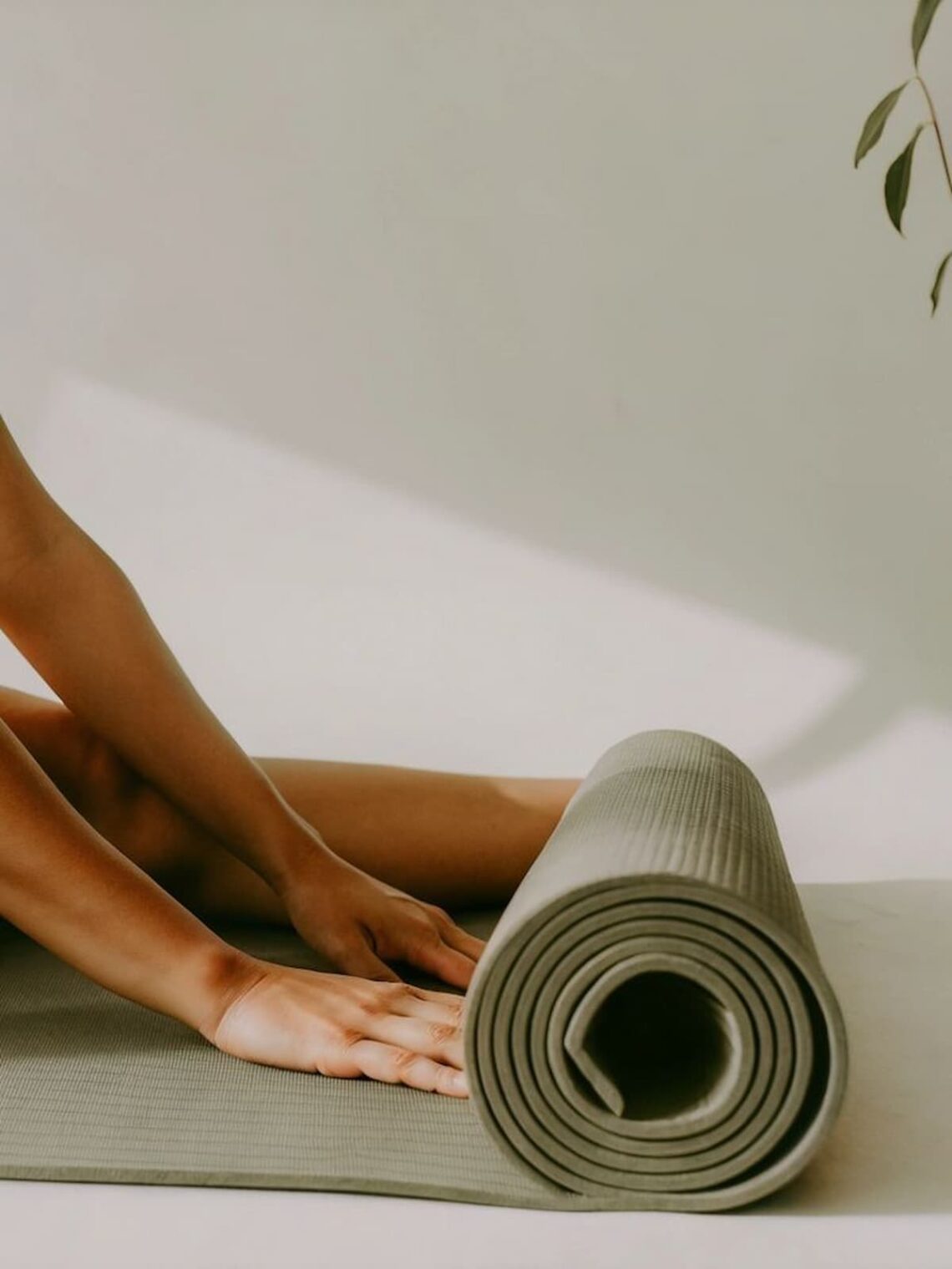 Hands resting on a yoga mat in soft natural light, symbolizing calm and commitment.