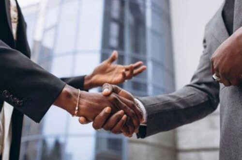 Close-up imagery of two men discussing over a handshake.