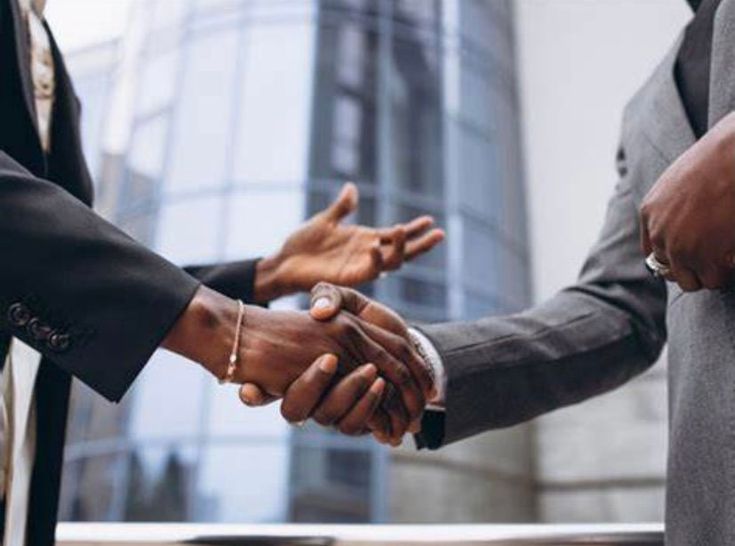 Close-up imagery of two men discussing over a handshake.