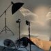A cluttered photography studio with equipments, and light beams cutting through